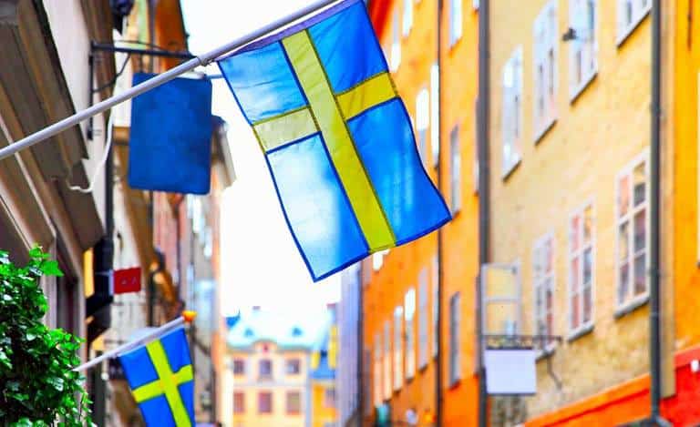 Två svenska flaggor hänger på fasaden av en byggnad
