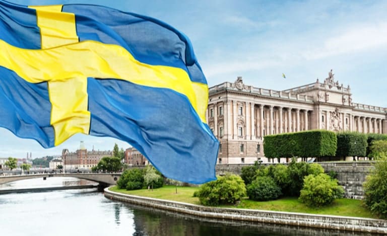 Svensk flagga framför en regeringsbyggnad